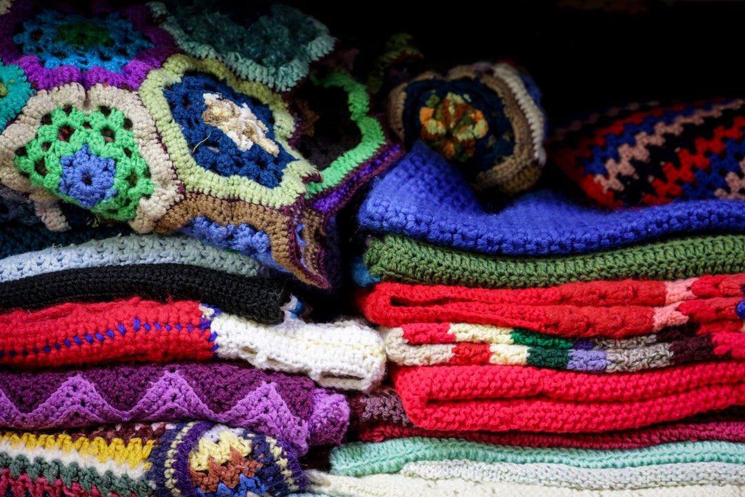 Pride throw blanket gift guide — a cozy stack of colorful folded blankets